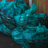 Oddly beautiful teal trash bags full of garbage
